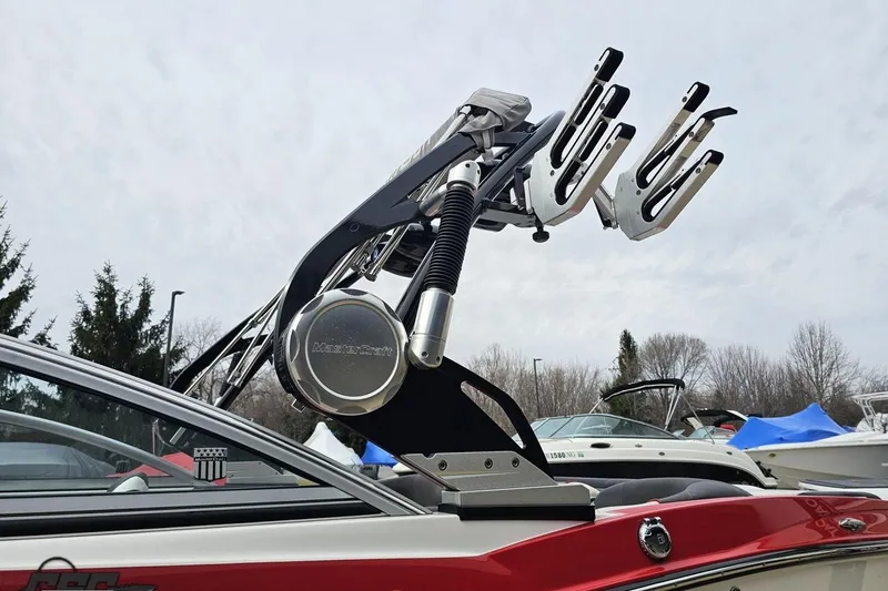 Slide: The Image of 2013 MasterCraft X-10 boat with wakeboard tower, docked outdoors under cloudy sky. - 28