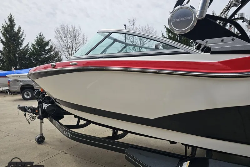 Slide: The Image of 2013 MasterCraft X-10 boat with red and white design on a trailer. - 29