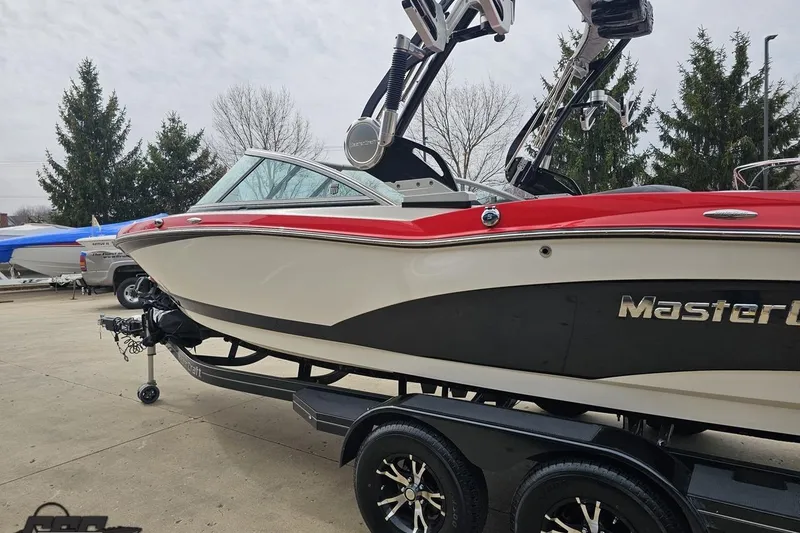 Slide: The Image of 2013 MasterCraft X-10 boat with red and white exterior on a trailer. - 30