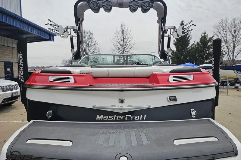 Slide: The Image of 2013 MasterCraft X-10 boat with red and white detailing, parked at a marina. - 36