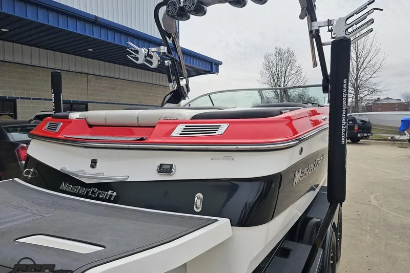 Slide: The Image of 2013 MasterCraft X-10 boat with red and white design, parked outdoors. - 38