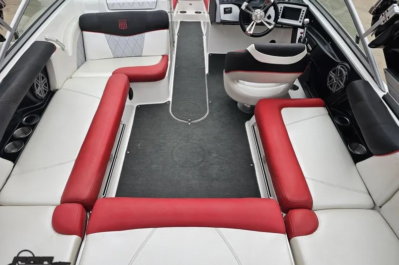 Slide: The Image of 2013 MasterCraft X-10 boat interior with red and white seating, modern dashboard, and cup holders. - 47