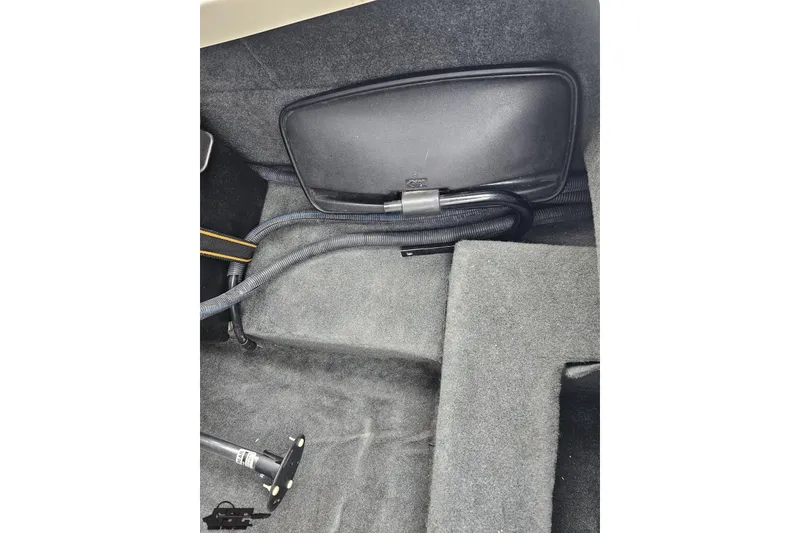 Slide: The Image of 2013 MasterCraft X-10 interior storage compartment with hoses and carpeted flooring. - 58