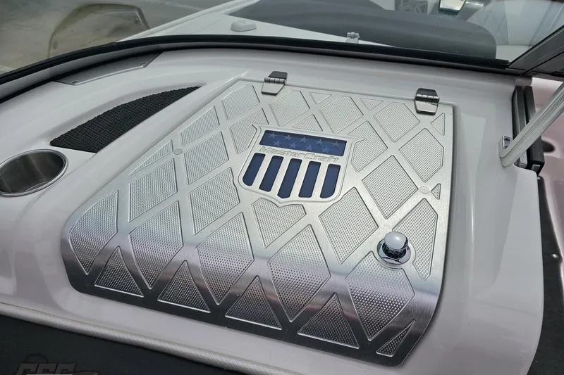 Slide: The Image of 2013 MasterCraft X-10 boat engine cover with sleek metallic design and logo detailing. - 59