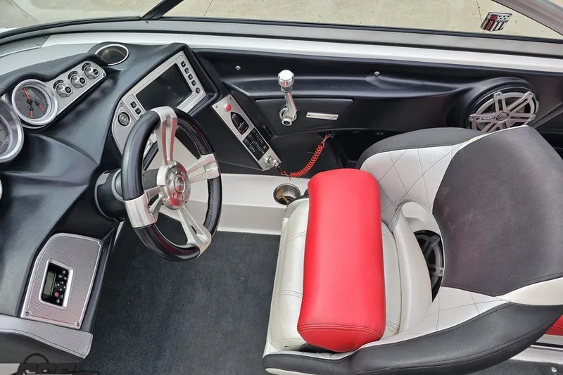 Slide: The Image of Interior of a 2013 MasterCraft X-10 boat featuring steering wheel and dashboard controls. - 62
