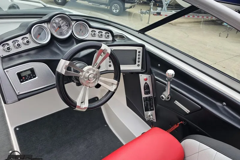 Slide: The Image of 2013 MasterCraft X-10 boat dashboard with steering wheel, gauges, and control panel. - 64