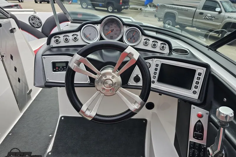 Slide: The Image of 2013 MasterCraft X-10 boat dashboard with steering wheel, gauges, and control panel. - 65