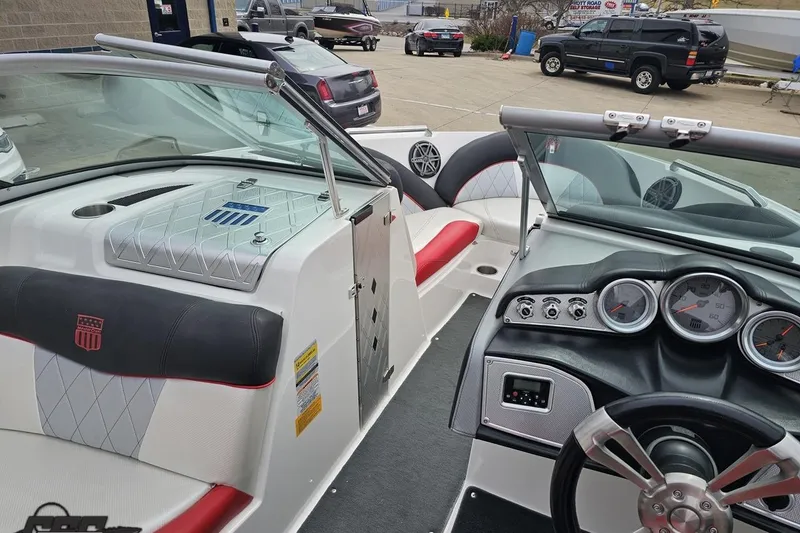 Slide: The Image of 2013 MasterCraft X-10 boat interior with dashboard and seating, parked in a lot. - 70