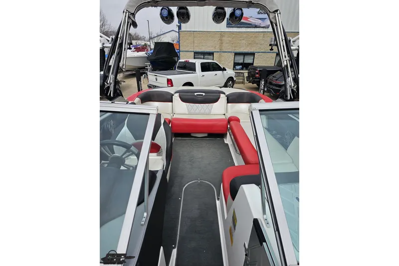 Slide: The Image of 2013 MasterCraft X-10 boat interior with red and white seating, parked outdoors. - 86