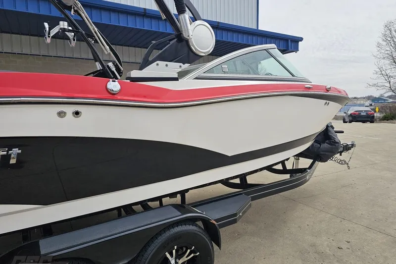 Slide: The Image of 2013 MasterCraft X-10 boat with red and white exterior on a trailer. - 9