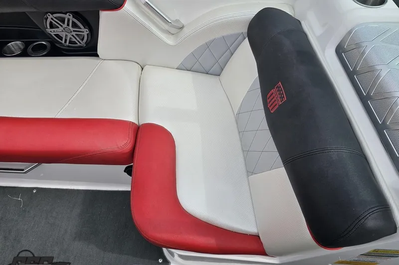 Slide: The Image of 2013 MasterCraft X-10 boat interior with red and white seating, speaker, and cup holders. - 90