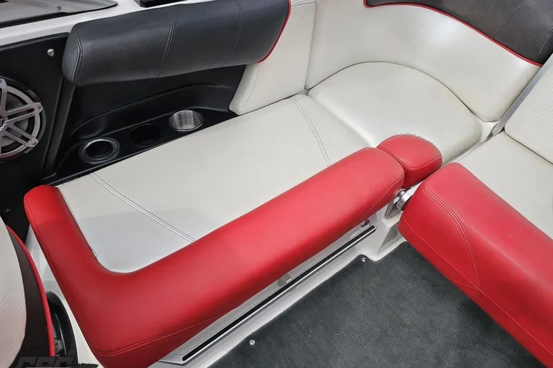 Slide: The Image of 2013 MasterCraft X-10 boat interior with red and white seating, cup holders, and speaker. - 93