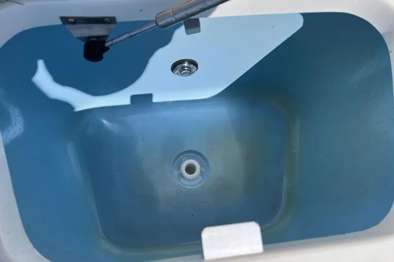 Slide: The Image of Livewell interior of 2017 Boston Whaler 180 Dauntless boat, showing drain and fittings. - 10