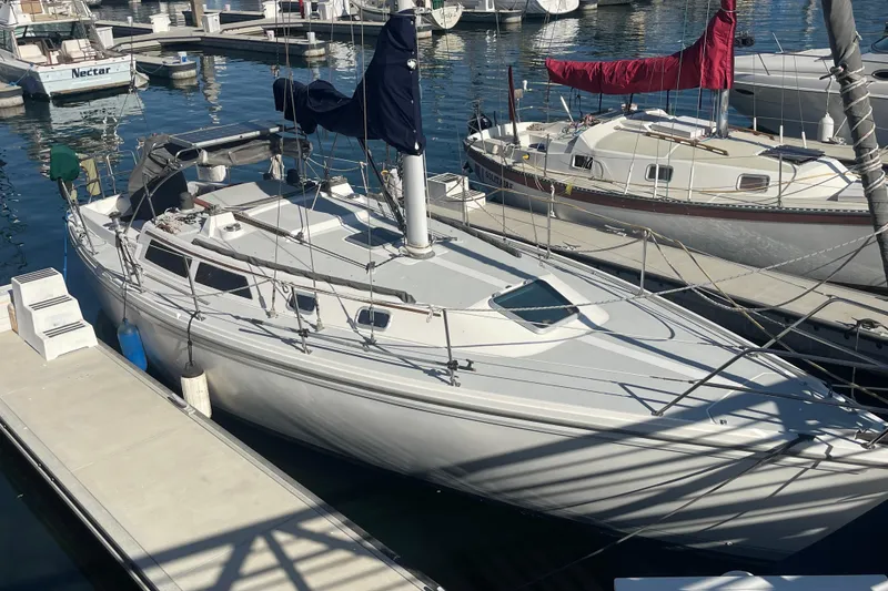 Slide: The Image of 1989 Catalina 36 sailboat docked at marina, surrounded by other boats. - 1