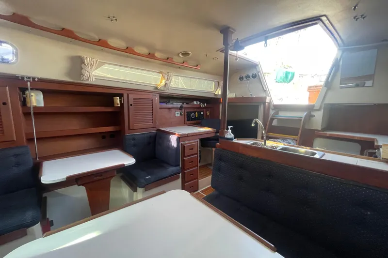 Slide: The Image of Interior of a 1989 Catalina 36 sailboat with cozy seating and wooden cabinetry. - 11