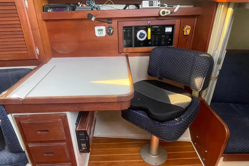 Slide: The Image of Interior of a 1989 Catalina 36 sailboat with navigation station and cushioned chair. - 12