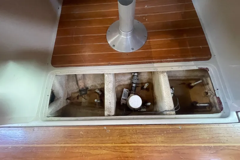 Slide: The Image of Bilge compartment of a 1989 Catalina 36 sailboat with visible components and wooden flooring. - 20