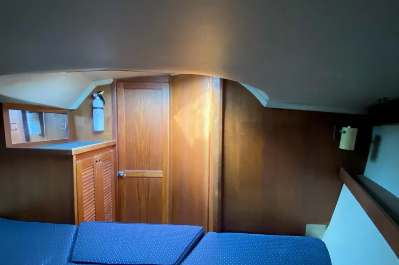 Slide: The Image of Interior cabin of a 1989 Catalina 36 sailboat with wooden finishes and blue cushions. - 21