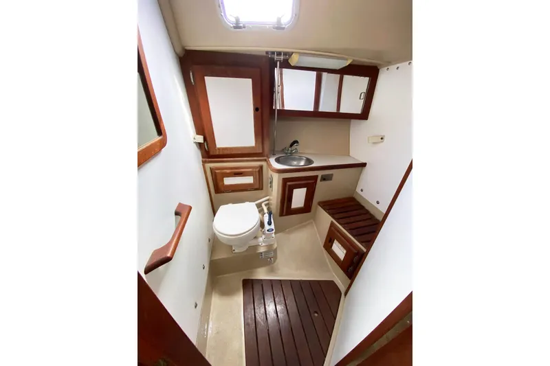Slide: The Image of 1989 Catalina 36 yacht bathroom with wooden accents, sink, and toilet. - 24