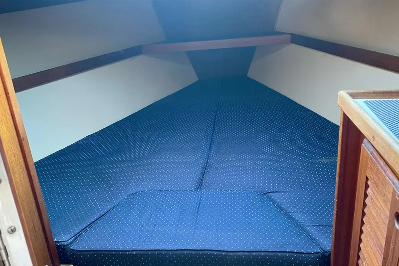 Slide: The Image of Interior cabin of a 1989 Catalina 36 sailboat with blue cushioned bedding. - 28