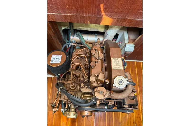 Slide: The Image of Engine of a 1989 Catalina 36 sailboat, showcasing detailed components and caution label. - 33