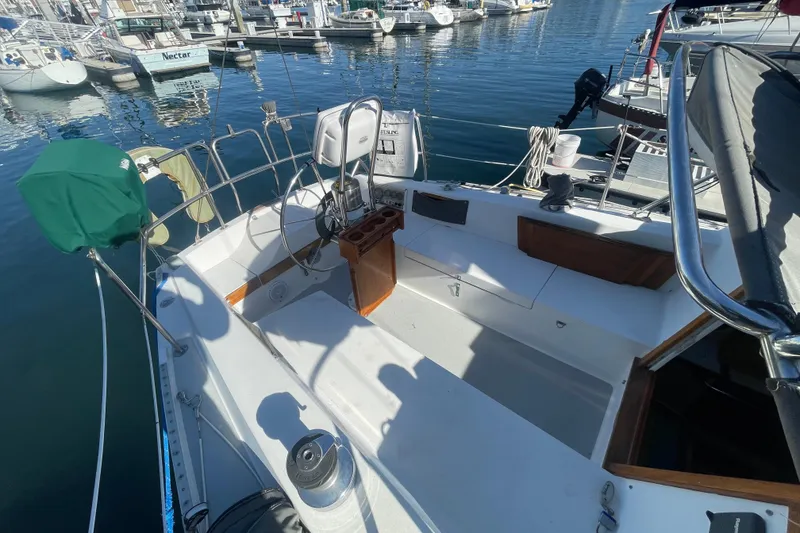 Slide: The Image of 1989 Catalina 36 sailboat cockpit with marina view, featuring steering wheel and seating area. - 5