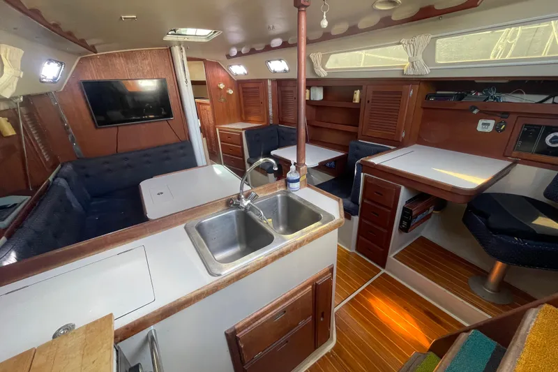Slide: The Image of Interior of a 1989 Catalina 36 sailboat with kitchen, seating, and wooden cabinetry. - 7