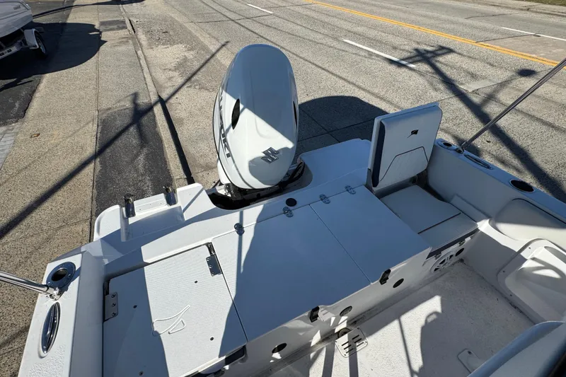 Slide: The Image of 2025 Stingray 173 CC boat with outboard motor, parked on a street. - 2