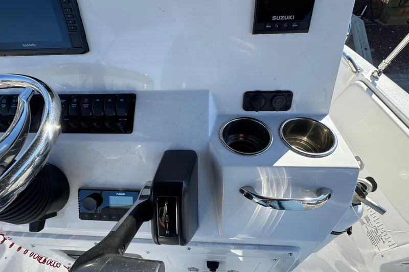 Slide: The Image of 2025 Stingray 173 CC boat dashboard with steering wheel, controls, and cup holders. - 7