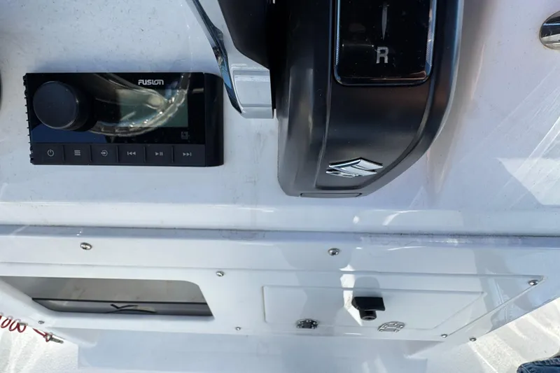 Slide: The Image of Control panel of 2025 Stingray 173 CC boat featuring Fusion audio system and throttle lever. - 9