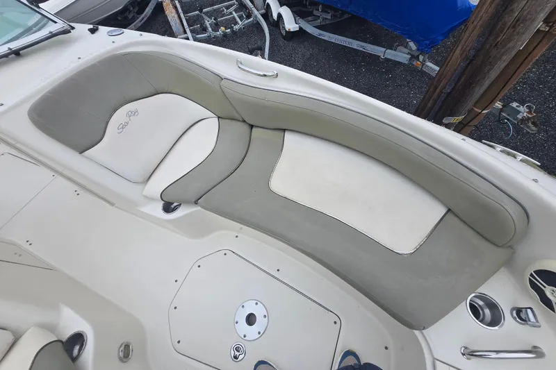 Slide: The Image of 2007 Sea Ray 240 Sundeck boat interior with cushioned seating and cup holders. - 10