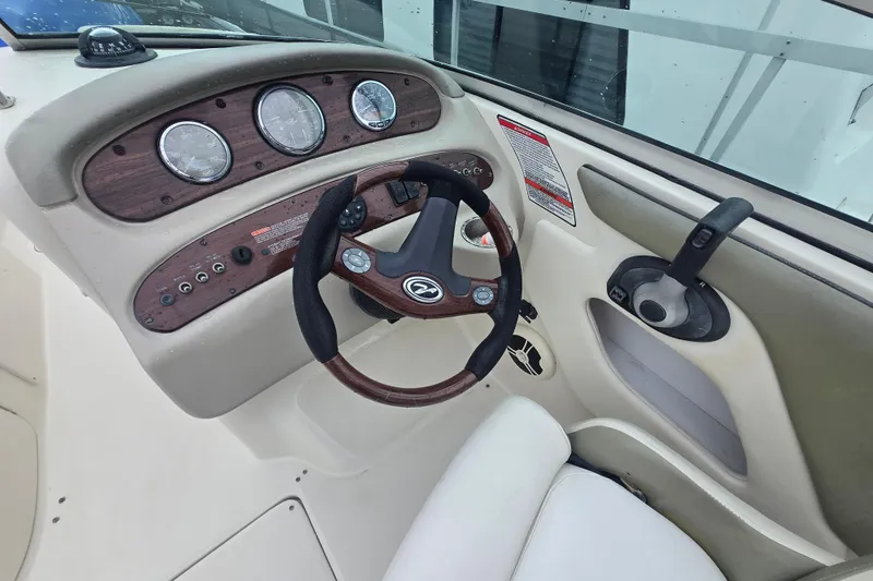 Slide: The Image of 2007 Sea Ray 240 Sundeck helm with wood-accented dashboard and steering wheel. - 15