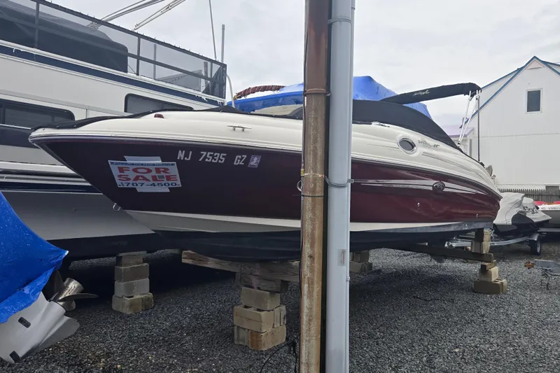 Slide: The Image of 2007 Sea Ray 240 Sundeck boat for sale, elevated on blocks, with visible contact information. - 21