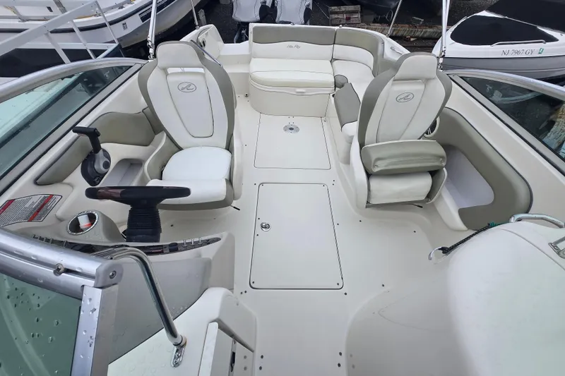 Slide: The Image of 2007 Sea Ray 240 Sundeck interior with white seating and steering wheel. - 3