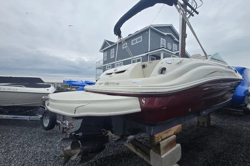 Slide: The Image of 2007 Sea Ray 240 Sundeck boat on blocks, near a coastal house. - 5