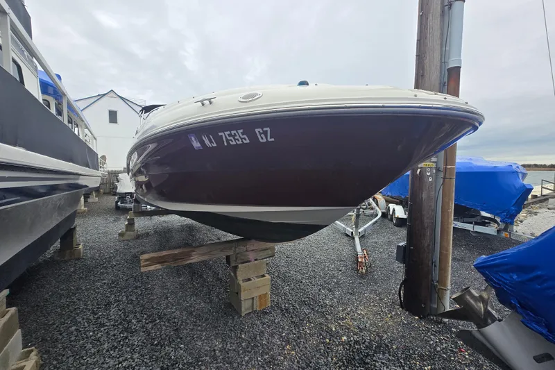 Slide: The Image of 2007 Sea Ray 240 Sundeck boat on blocks, gravel lot, overcast sky. - 6