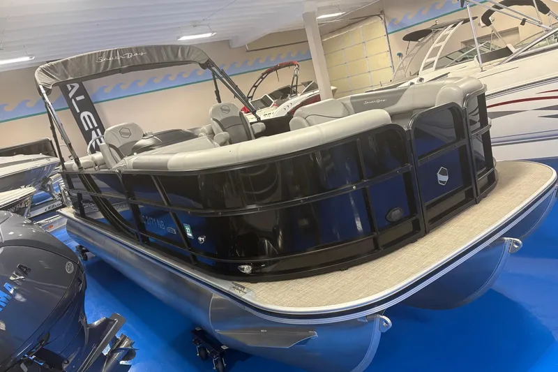 Slide: The Image of 2022 South Bay 224 RS 3.0 pontoon boat displayed in showroom with sleek design. - 2