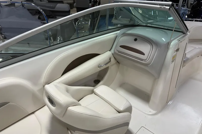 Slide: The Image of Interior of a 2005 Chaparral 236 SSi boat, featuring white seating and dashboard. - 8