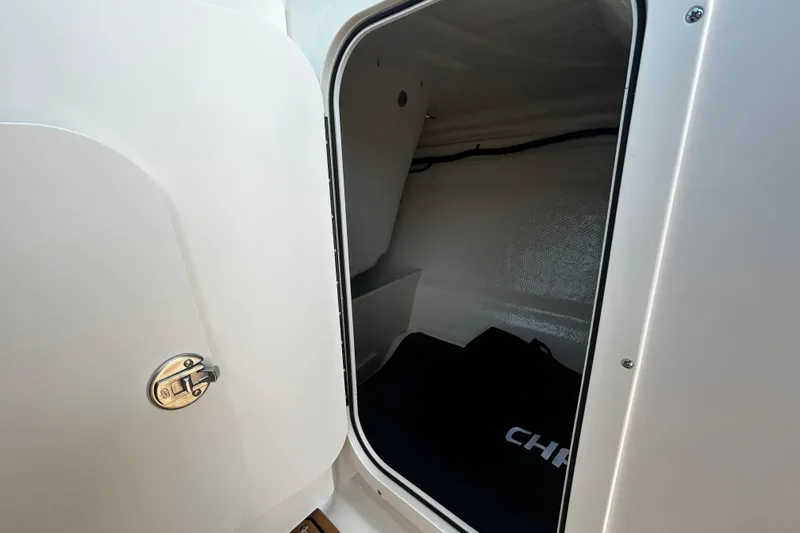 Slide: The Image of Interior storage compartment of 2026 Chaparral 23 SSi OB boat, featuring secure latch. - 13