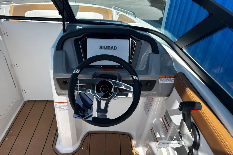 Slide: The Image of 2026 Chaparral 23 SSi OB boat dashboard with Simrad display and steering wheel. - 14