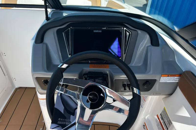 Slide: The Image of 2026 Chaparral 23 SSi OB boat dashboard with steering wheel and Simrad display. - 15