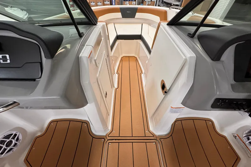 Slide: The Image of 2026 Chaparral 23 SSi OB boat interior with tan and white seating, docked outdoors. - 8
