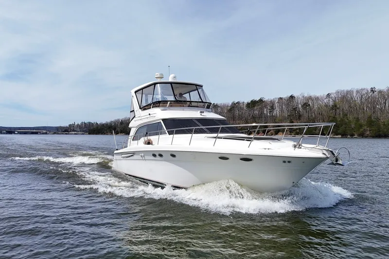 Slide: The Image of 1999 Sea Ray 480 Sedan Bridge cruising on a scenic lake. - 11