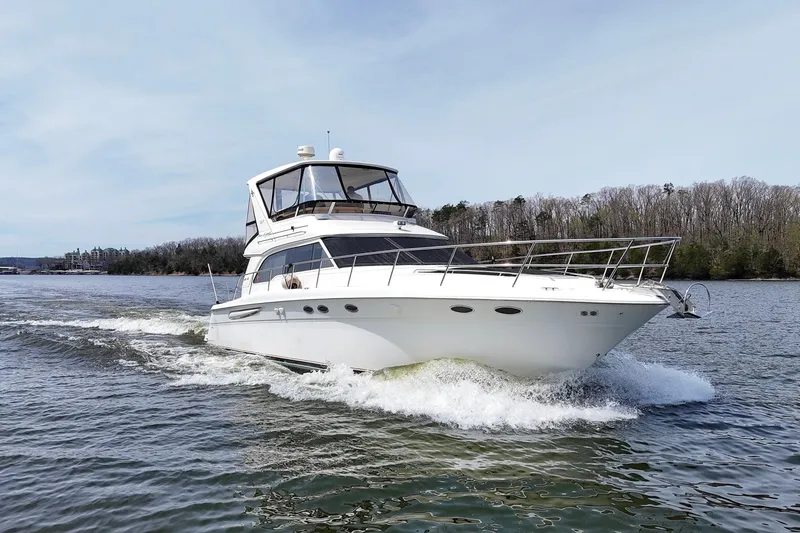 Slide: The Image of 1999 Sea Ray 480 Sedan Bridge yacht cruising on a scenic lake. - 12