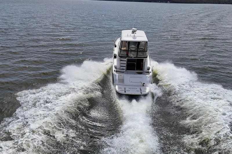 Slide: The Image of 1999 Sea Ray 480 Sedan Bridge cruising on open water, creating a dynamic wake. - 18