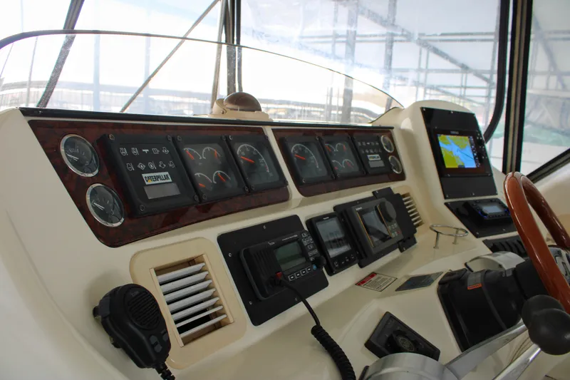 Slide: The Image of 1999 Sea Ray 480 Sedan Bridge helm with gauges, controls, and navigation display. - 22