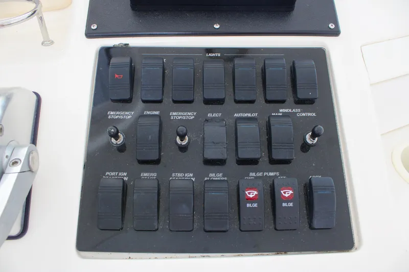 Slide: The Image of Control panel of a 1999 Sea Ray 480 Sedan Bridge yacht with various switches and toggles. - 26