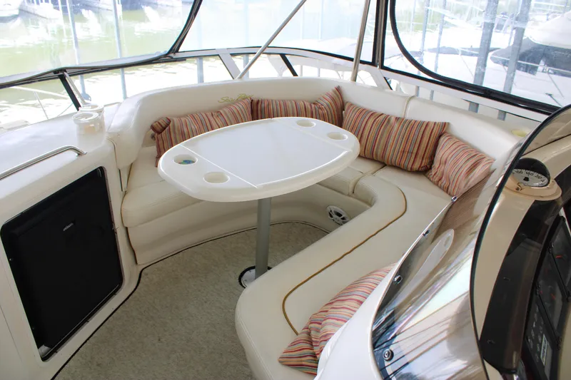 Slide: The Image of 1999 Sea Ray 480 Sedan Bridge interior with cushioned seating and table. - 30