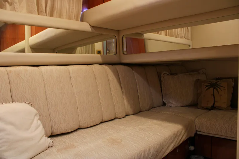 Slide: The Image of Interior of 1999 Sea Ray 480 Sedan Bridge with beige seating and decorative pillows. - 38