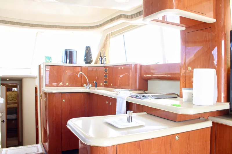 Slide: The Image of Luxurious kitchen interior of a 1999 Sea Ray 480 Sedan Bridge yacht, featuring wood cabinetry. - 41